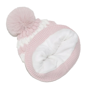 Detailed view of pink and white knit hat with soft faux fur lining and plush pompom top