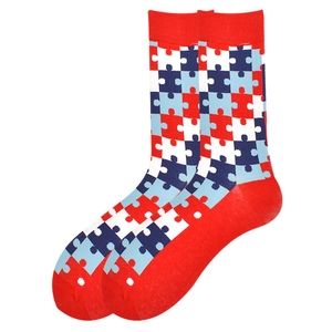 Close-up of red cotton crew socks featuring blue and white jigsaw puzzle pattern