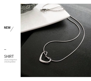 Macro detail of high-polish hollow heart pendant on a premium silver snake chain