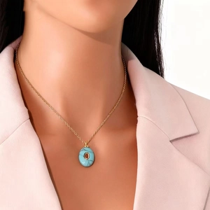 Oval blue natural stone pendant necklace in gold stainless steel worn by a model