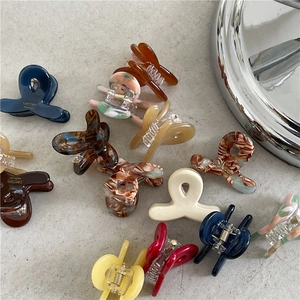 Chic acetate hair claws in various marble and tortoiseshell patterns for daily styling