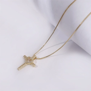 Gold cross pendant necklace with heart detail and micro-set cubic zirconia stones