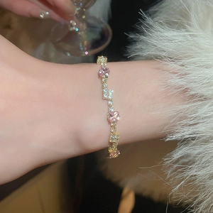 Close-up of pink square zircon bracelet with gold pavé settings on model's wrist