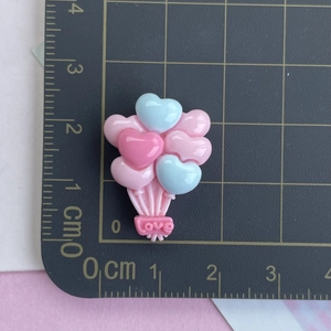 Détail de ballons cœur en résine rose et bleu avec texte LOVE sur tapis gradué