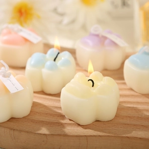 Cute cat paw scented candles in pastel colors on a wooden tray for home decor