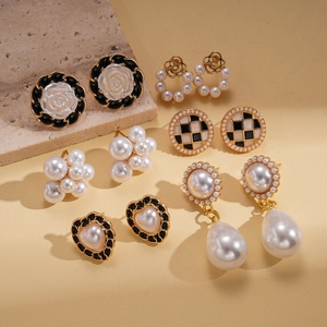 Elegant 12-piece gold finish earring set with pearls and heart designs on stone props