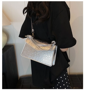 Silver crocodile texture handbag with metallic finish worn as a crossbody bag