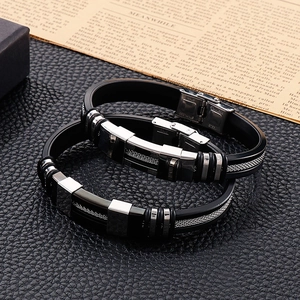 Men's fashion black silicone and stainless steel bracelet set on a textured leather surface
