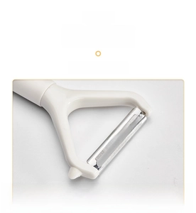 Detail of stainless steel Y-shaped peeler blade for fruits and vegetables on white background