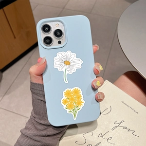 Detail of light blue phone case with daisy floral prints on a textured wooden background