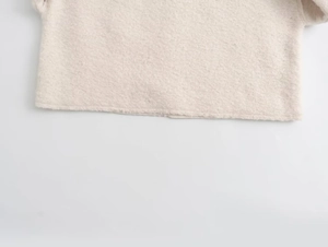 Detail of soft beige knit fleece texture on a casual loose sweatshirt for women