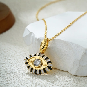 Detailed close-up of 18K gold evil eye pendant with enamel stripes and sparkling zircon