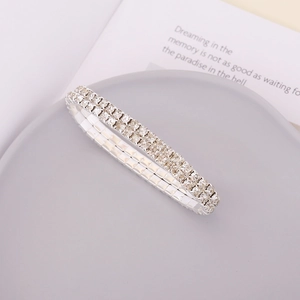 Detail of silver double-row rhinestone elastic bracelet on minimalist grey display tray