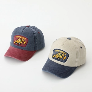 Close-up of kids' baseball caps featuring detailed excavator embroidery and HYC KIDS patch