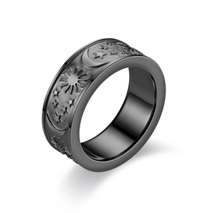 Primer plano detallado de anillo de acero de titanio negro con grabados de sol luna y estrellas