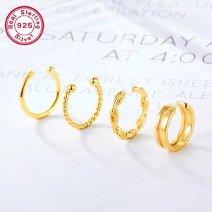 Macro view of four assorted gold-plated 925 sterling silver ear cuffs in twisted and chain styles