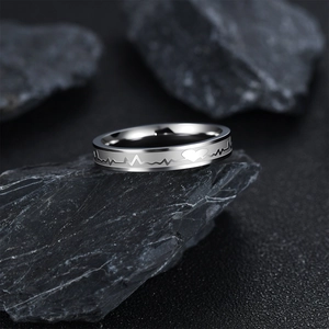 Polished stainless steel EKG heartbeat ring for couples on a textured slate stone