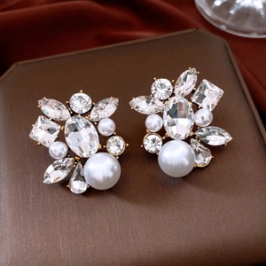 Macro shot of French style gold earrings with crystals and teardrop pearls
