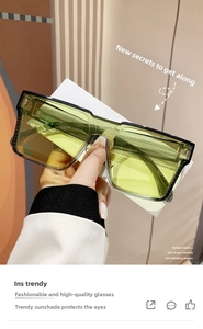 Macro shot of stylish emerald green oversized sunglasses with gradient lenses