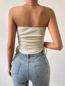 Beige ribbed knit tube top with side drawstring detail, styled with light blue jeans
