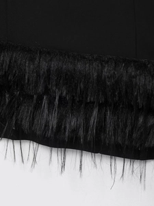 Détail d'une robe noire extensible montrant la bordure en plumes sur l'ourlet