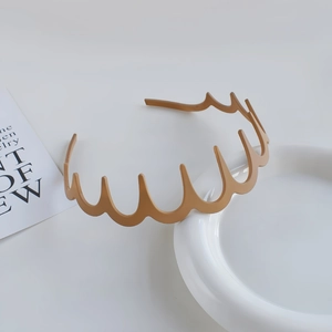 Close-up of light brown wavy headband with inner teeth for secure grip and matte finish