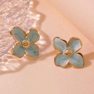 Detailed close-up of light blue enamel four-petal flower earrings in stainless steel