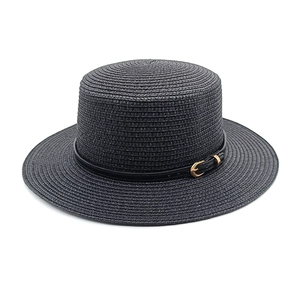 Detailed view of woven straw texture on black boater hat with leather buckle band