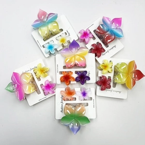 Macro detail of gradient resin plumeria hair claw clips in large and small sizes