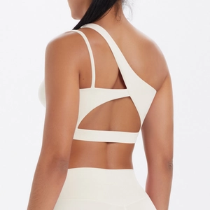 Macro detail of white sports bra with asymmetrical straps and open back cutout design