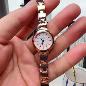 Close-up of elegant rose gold women's quartz watch with crystal scales on white dial