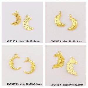 Detail of four golden moon alloy charms with floral and face designs for DIY jewelry