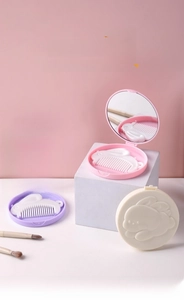 Close-up of portable rabbit-shaped round mirror and comb set in macaron colors