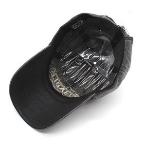 Detail view of washed cotton baseball cap interior with black sweatband and 100% cotton tag