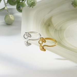 Elegant gold and silver leaf-shaped stainless steel open rings on green agate tray