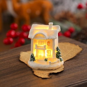 Close-up of a white resin Christmas City Hall night light with warm LED glow and snow texture