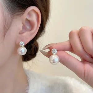 Elegant sterling silver stud earrings featuring round white pearls and sparkling zircons