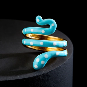 Snake wrap ring with blue polka dot enamel and 18K gold plating on a black stand