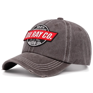 Detail of dark gray washed cotton baseball cap with vintage motor oil embroidery
