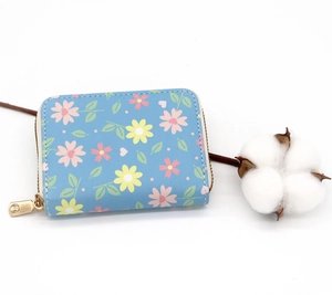 Detailed close-up of blue floral card holder with textured leather and gold zipper
