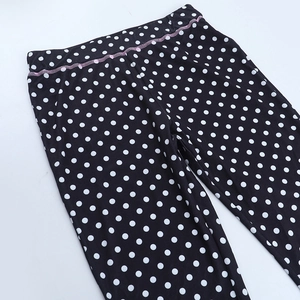 Detail of polka dot trousers featuring elastic waistband and contrast pink stitching detail