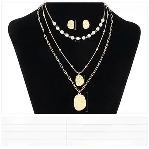 Detail view of multi-layer stainless steel necklace set with pearls on jewelry stand