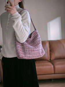 Gros plan détaillé d'un sac hobo tissé rose avec une texture épaisse en fil mélangé