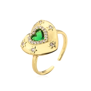 Macro detail of 18K gold-plated heart ring with green gem and zircon stars