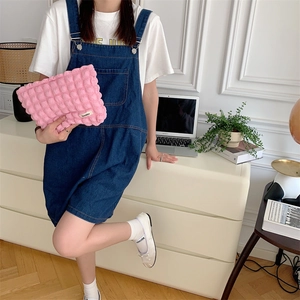 Pink bubble texture makeup bag with Seakla brand tag held by a model in casual lifestyle setting