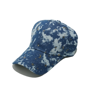 Detailed embroidery of gold stars and moon on blue tie-dye denim baseball cap
