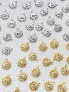 Macro shot of gold and silver sunburst evil eye charms with cubic zirconia inlay