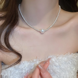 Close-up of silver geometric pearl choker on model collarbone area
