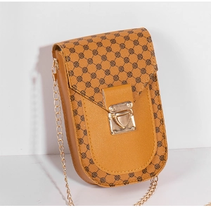 Detailed side view of yellow textured mobile phone bag with clover pattern and gold chain