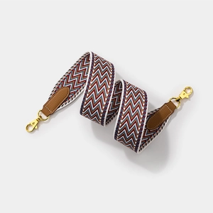Wide woven geometric strap with brown leather and gold hardware for crossbody bags
